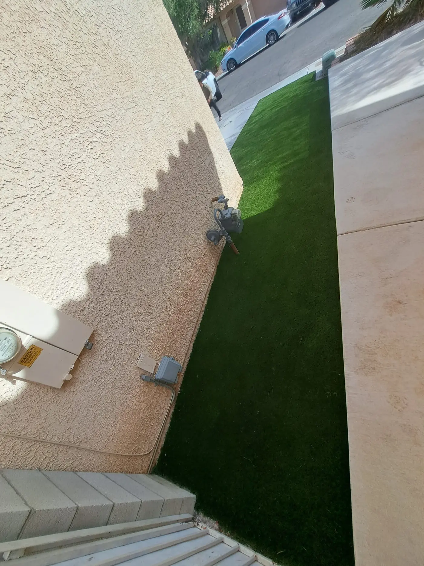 Side-yard strip of artificial turf for a dog run